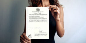 Image of a woman dressed in smart attire, holding a Certificate of Good Standing