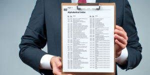 A man in a suit holding a clipboard displaying a list of limited company SIC codes in alphabetical order.