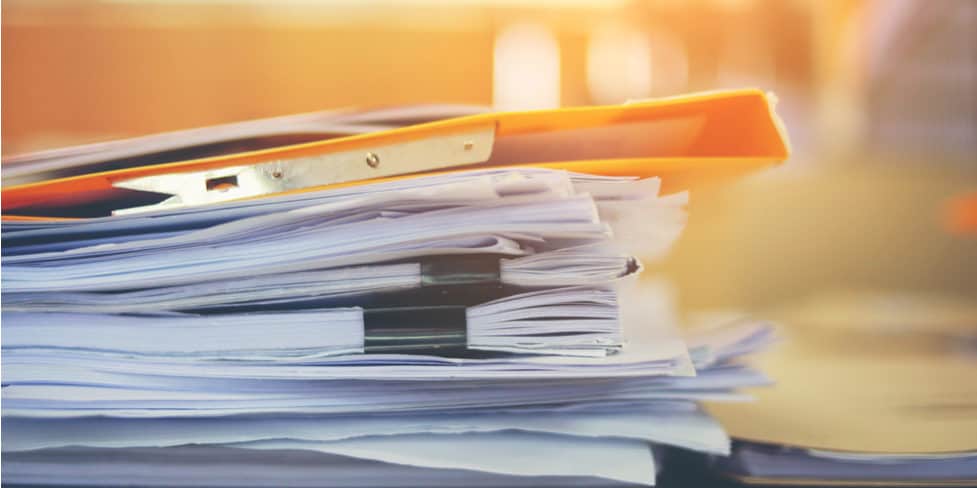 Image of a pile of documents and files sitting on top of a desk, illustrating the requirement to keep limited company records