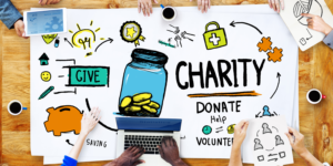 Overhead shot of a colourful illustration lying on a table displaying the concept of giving and charity - with people sitting around the table.