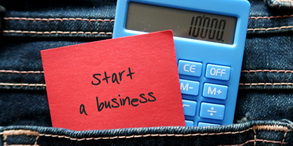 Red note and blue calculator in jeans pocket written START A BUSINESS , concept of a new small business owner calculating the startup cost to launch business on their own