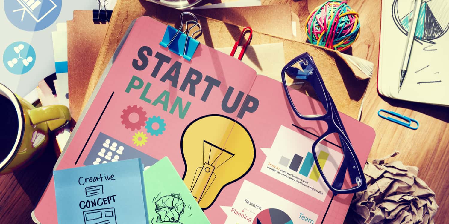 Desktop with start up plan and other strategy documents, illustrating starting a side business concept.