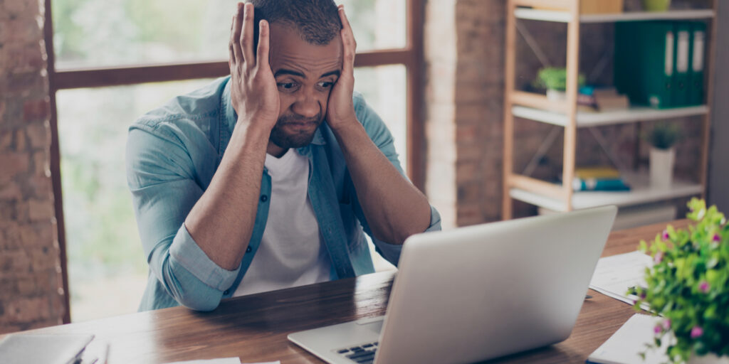 Man panicking in front of laptop