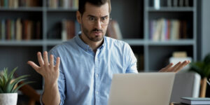 Man looking confusingly at computer