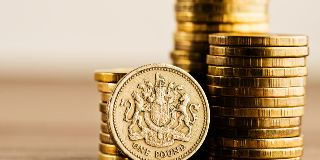 Pound GBP coin and gold money on the desk