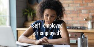 Thoughtful young black woman sitting at desk using calculator.