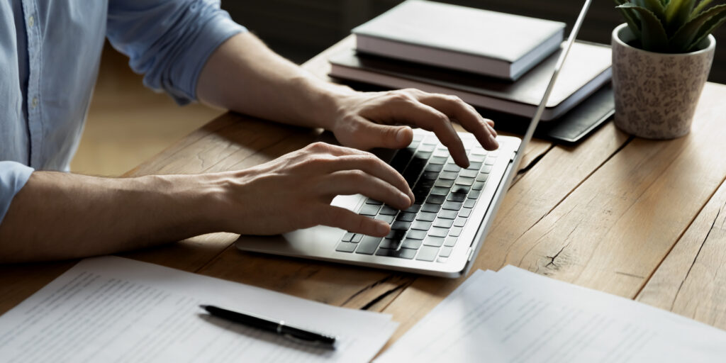 Man sat at desk working on laptop