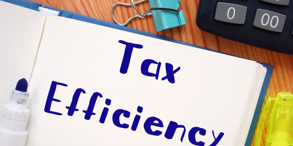 Notebook lying open on desk with the words 'Tax Efficiency' written in blue marker pen.