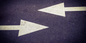 Concrete road with two white arrows pointing in different directions