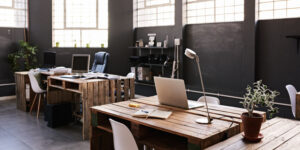 Modern office space with tables and chairs, computers and office supplies with no employees.