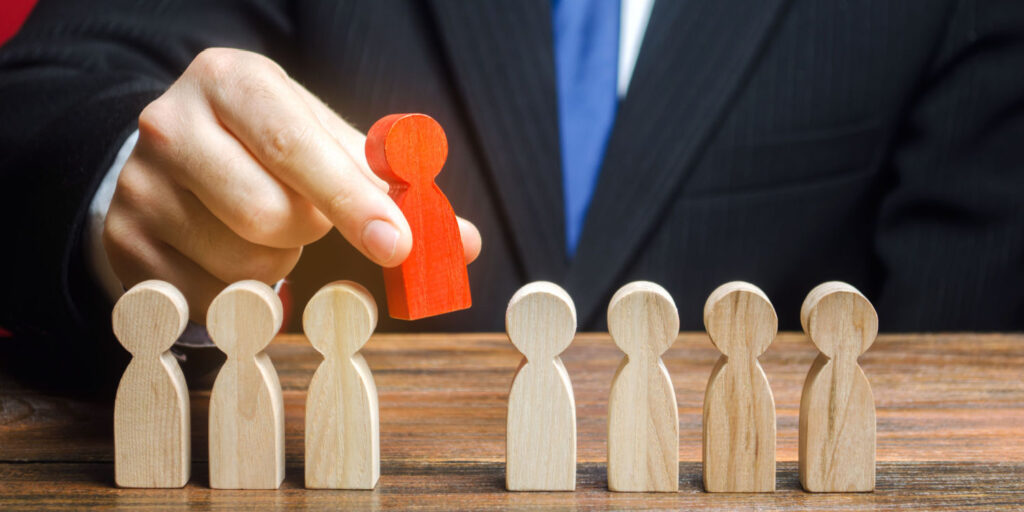 Businessman's hand removing a red peg from a row a yellow pegs, illustrating the removal of a PSC from a company or LLP.