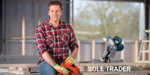 Portrait of sole trader holding his nailgun on indoor building construction site and looking at camera.