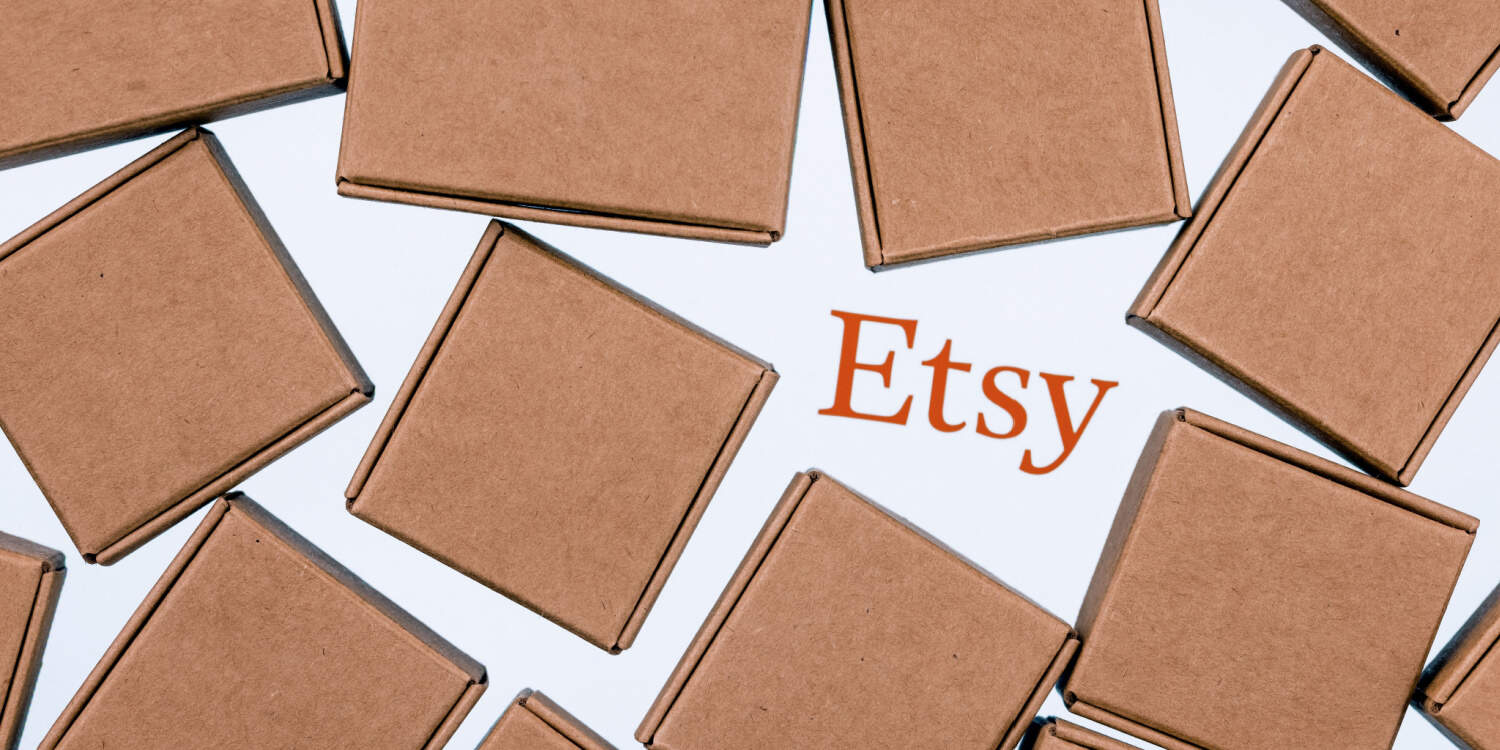 The Etsy logo on a white background surrounded by small parcel boxes.