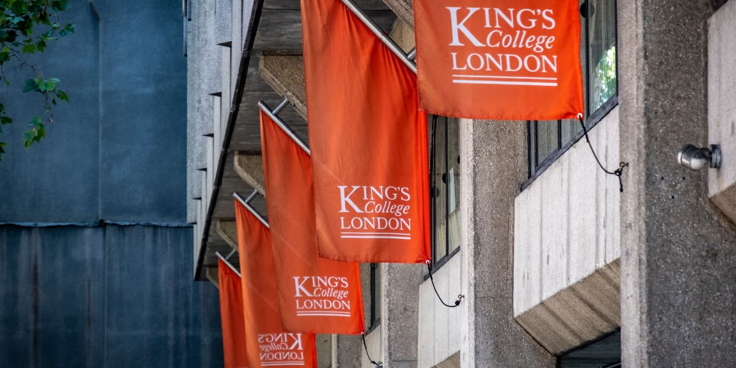 Image of red King's College London flags adorning the exterior of one of the university's buildings in London.