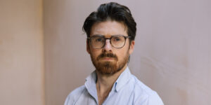 Portrait of Matt Dowling, Founder of the Freelancer Club wearing a light blue tailored shirt with open collar.