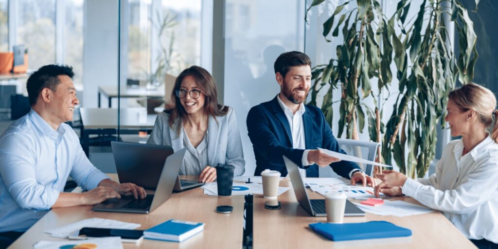 Four company directors at a baord meeting in a modern office.