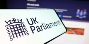 A mobile phone with the logo of the legislative body Parliament of the United Kingdom (UK) in front of the website.