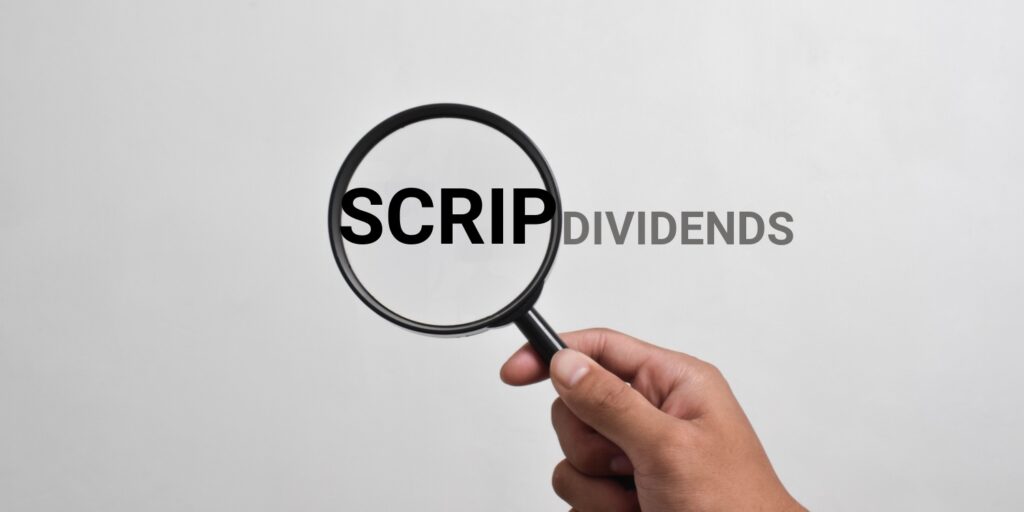 Male hand holding a magnifying glass over the words 'SCRIP DIVIDEND'.