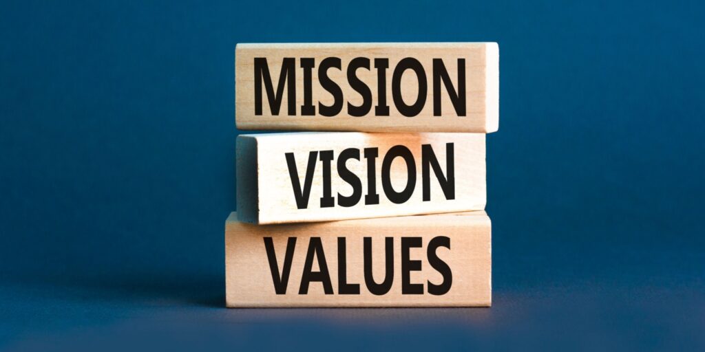 Image of three stacked wooden blocks with 'MISSION', 'VISION'M and 'VALUES' written on them