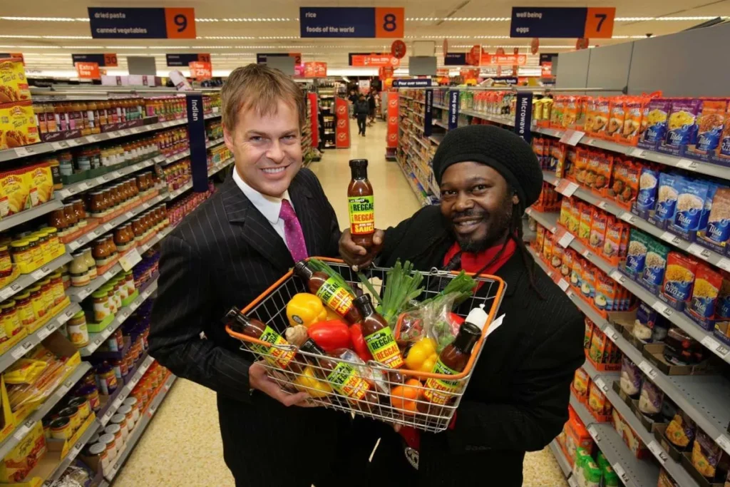 Levi Roots and Peter Jones displaying Reggae Reggae Sauce in Sainsbury's supermarket