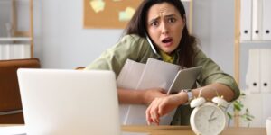 Stressed young businesswoman working under a deadline to file her annual accounts at Companies House.