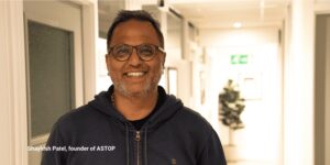 Close-up shot of Shaylesh Patel, founder of ASTOP, smiling at the camera with vacant office space in the background