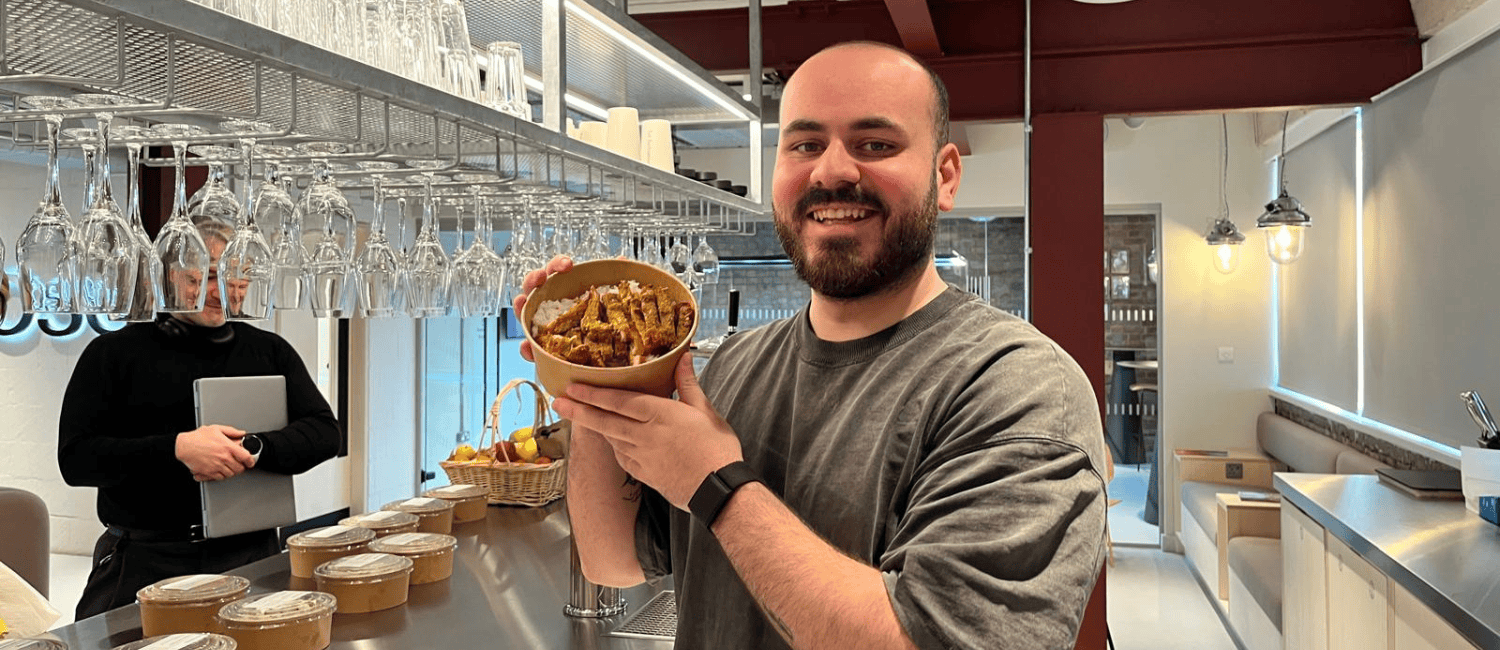 1st Formations employee holding up his lunch from Skewers.